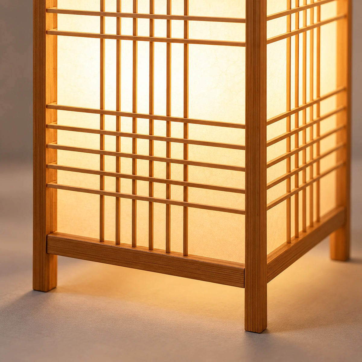 Detalhe da trama, estrutura em tom natural e pés da luminária de mesa Shoji acesa.