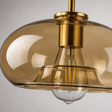 Close-up da luminária pendente de vidro âmbar cognac e acabamento dourado